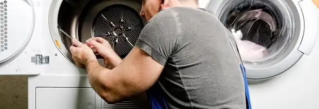 Dryer repair technician fixing a clothes dryer drum in Baltimore, MD