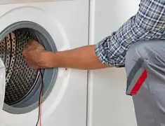 Dryer repair technician diagnosing and servicing a clothes dryer in Baltimore, MD