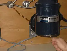 Garbage disposal repair technician tightening the mounting ring under a sink in Baltimore, MD