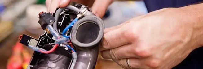 Vacuum repair technician reconnecting wiring and components in Baltimore, MD