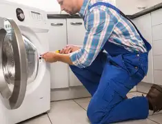 Washing machine repair technician servicing a front-load washer in Baltimore, MD