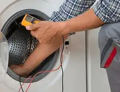 Washing machine repair technician testing a front-load washer with diagnostic tools in Baltimore, MD