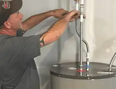 Water heater repair technician tightening supply line connections in Baltimore, MD
